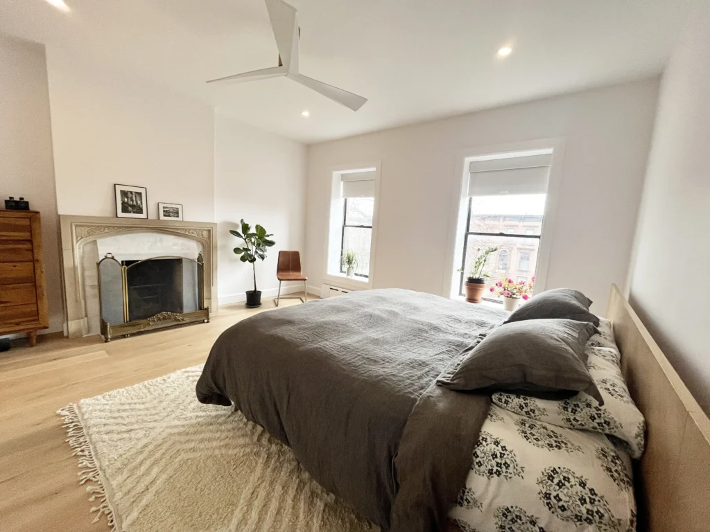 Bed facing marble retiled fireplace -beautiful natural light
